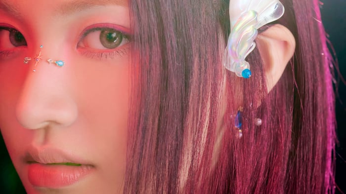 Liz from IVE with pink hair and face gems