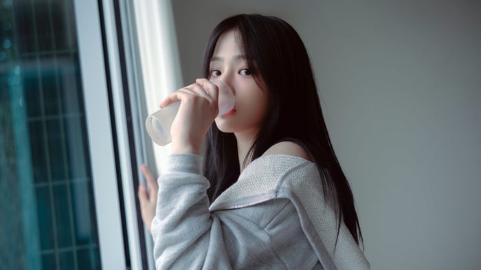Minji from NewJeans drinking from a cup