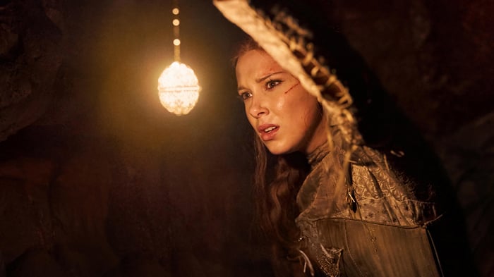 Millie Bobby Brown in a cave with a light