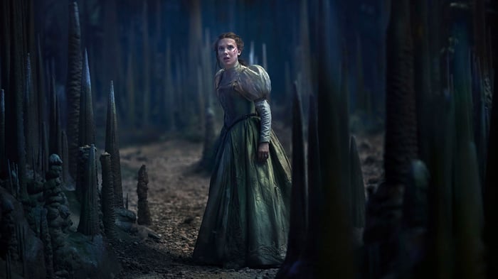 Millie Bobby Brown in a dark forest
