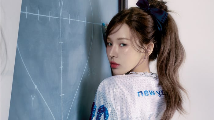 Wendy from Red Velvet poses by a chalkboard