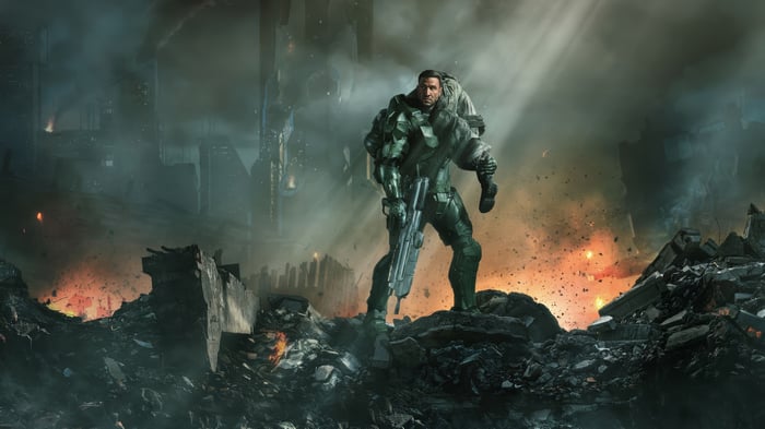 Master Chief carrying a person in a destroyed city