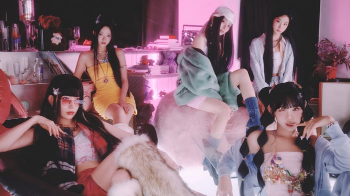 LE SSERAFIM members in a pink-lit room