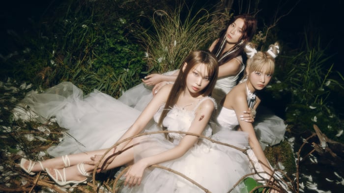 LE SSERAFIM members in white dresses in a forest