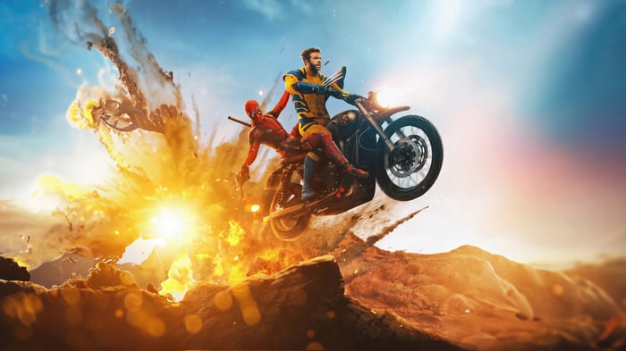 Deadpool and Wolverine on a motorcycle during an explosion