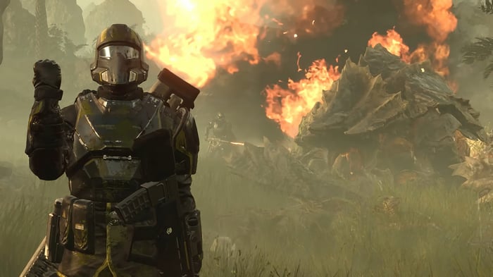 Helldivers 2 soldier fighting a large creature with fire