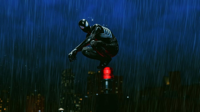 Spider-Man in a black suit crouches in the rain