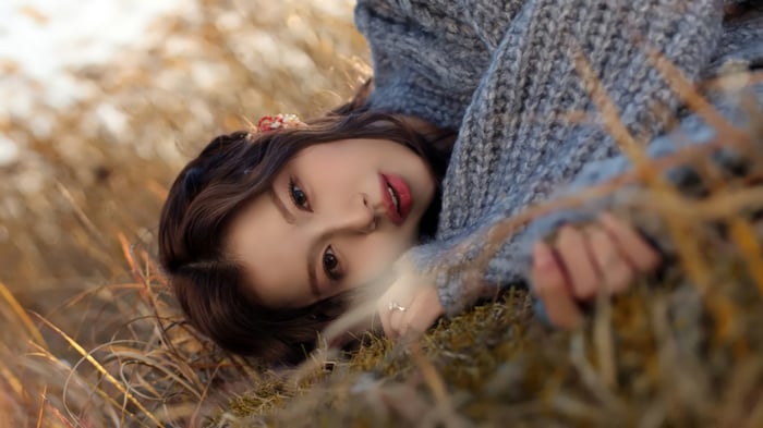 Sana from TWICE lying in dry grass