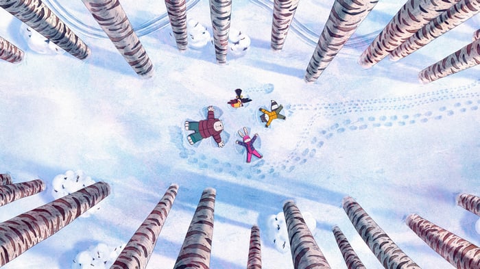 Four friends making snow angels in a winter forest