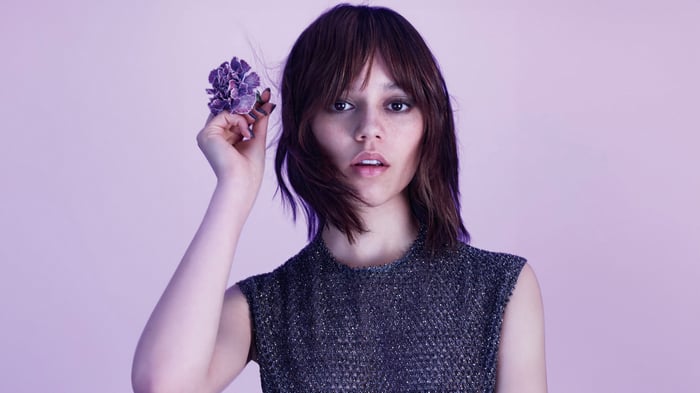 Jenna Ortega holding a purple flower
