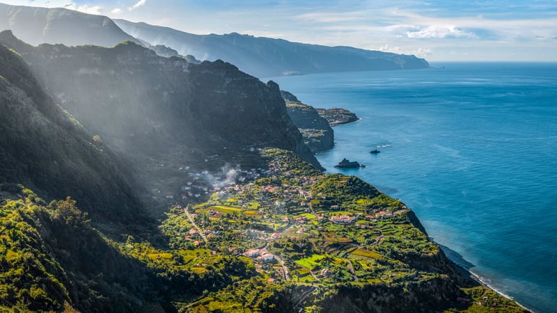 Coastal village nestled in green mountains by the sea