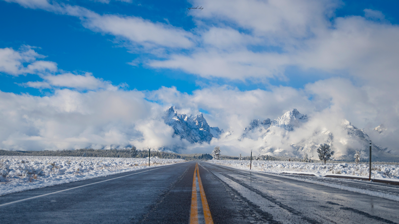 Snowy Road Leading to Mountains Under Cloudy Sky