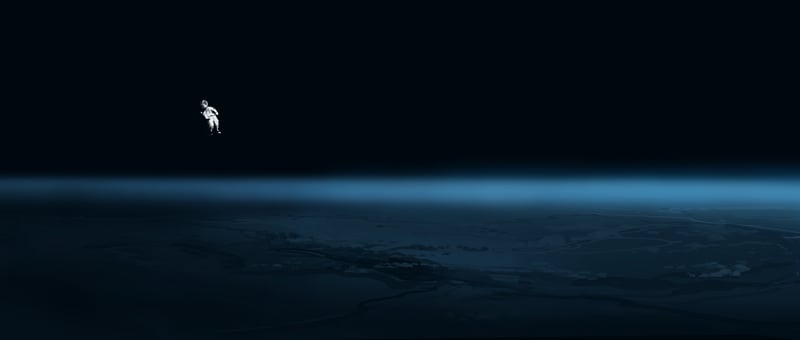 Astronaut floating above Earth in low light