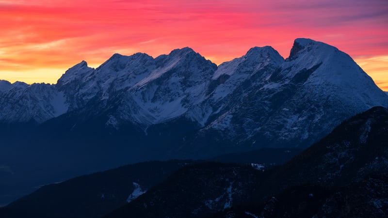 Snow-capped mountains at sunset with vibrant sky