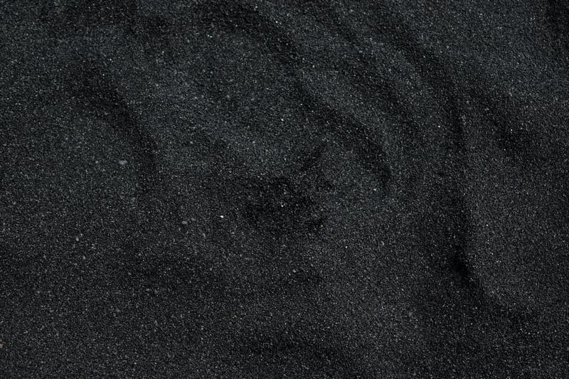Close-up of dark black sand with ripples
