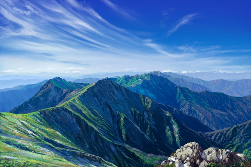 Jagged mountain range under a blue sky with wispy clouds