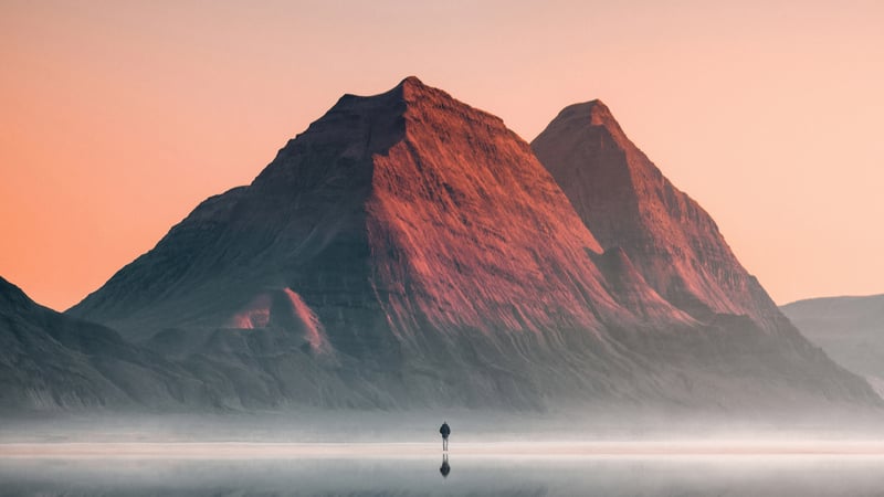 Man walks towards mountains at sunrise 4K