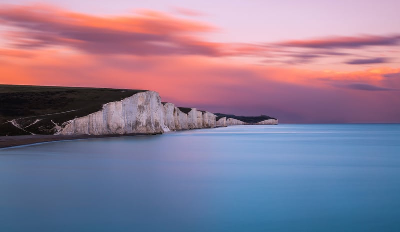 White cliffs and ocean at sunset with pink clouds