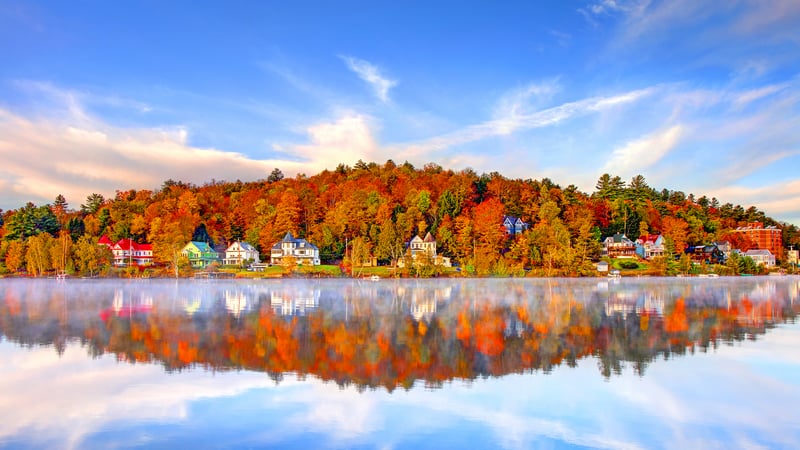 Autumn houses reflected in a misty lake