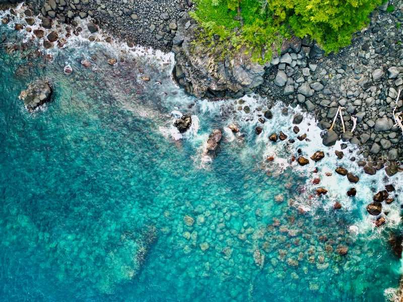 Aerial view of rocky coastline with clear turquoise water