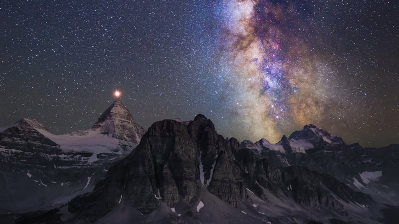 Milky Way over snow-capped mountains and a bright planet