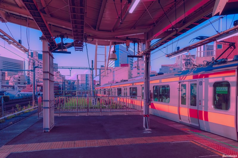 Train station platform with a train at sunset