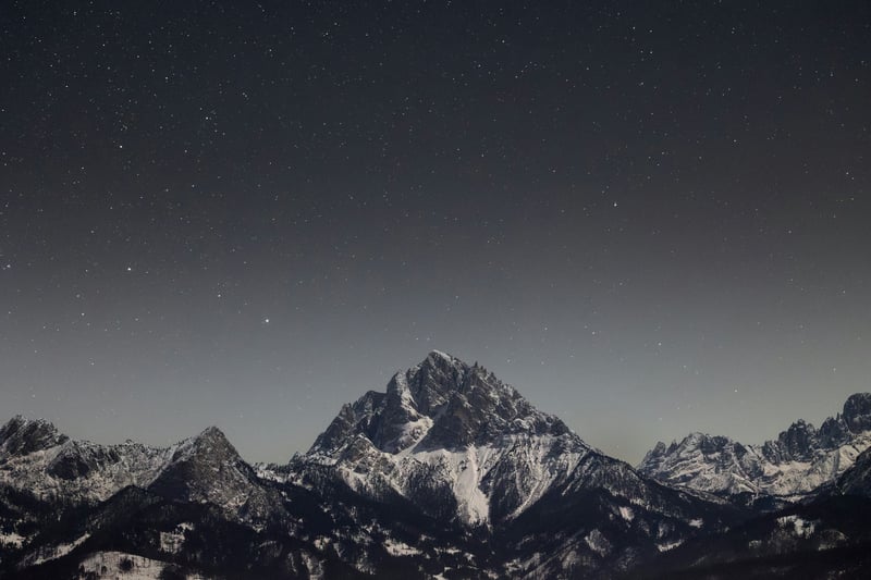 Snow-capped mountains under a starry night sky