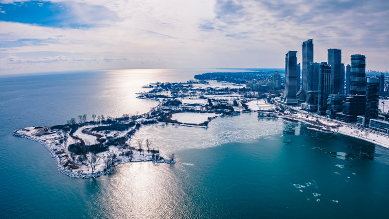Winter cityscape with frozen lake and skyscrapers
