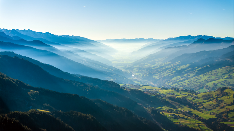Misty valley with mountains and a village