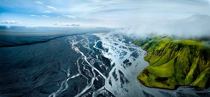 Aerial view of braided river delta with green hills