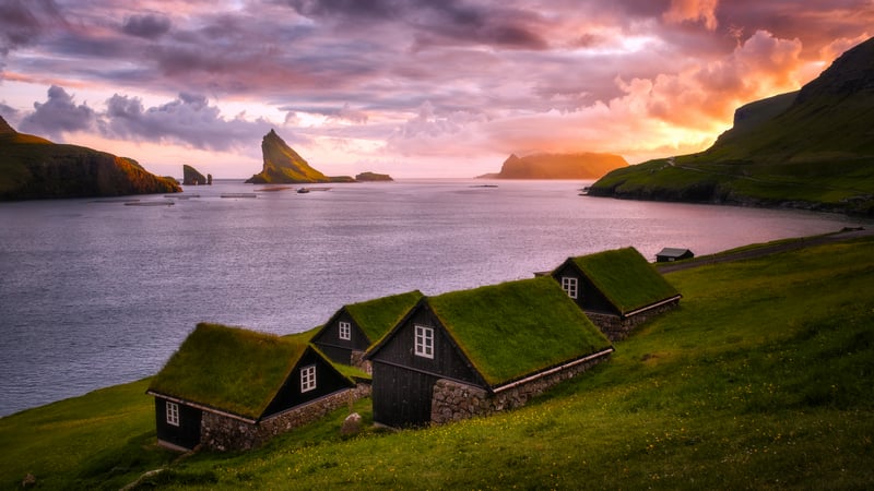 Faroe Islands turf-roofed houses by the sea at sunset