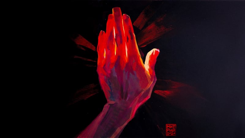 Hand illuminated by red light against black background