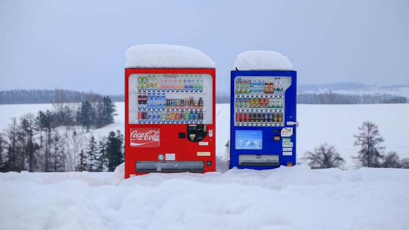 Two Coca-Cola vending machines in the snow