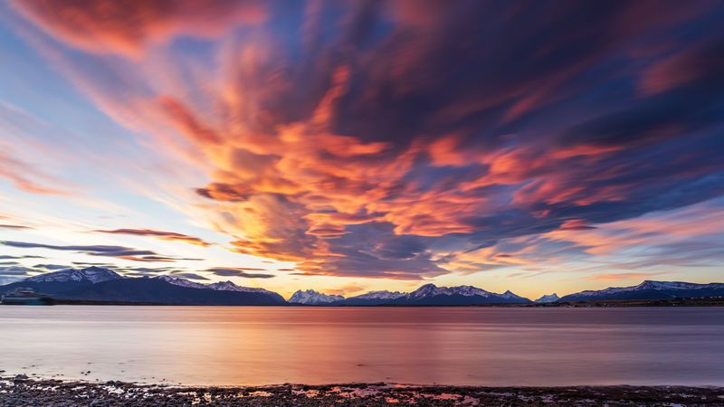 Dramatic sunset clouds over mountains and water