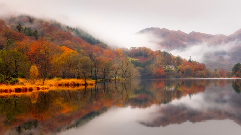 Autumn fog over a lake with reflections