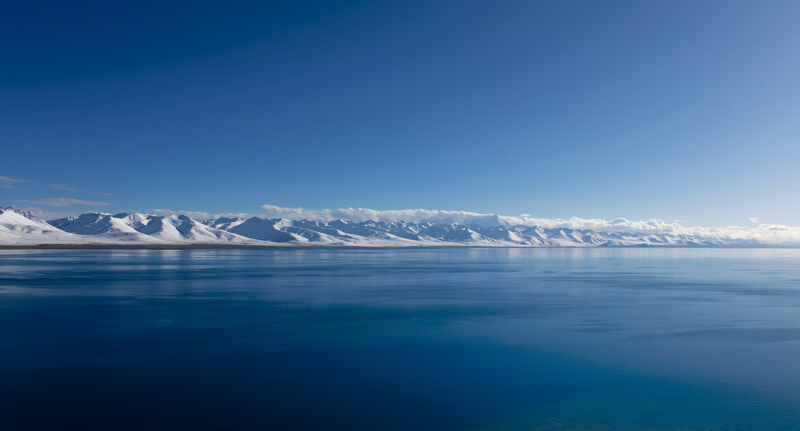 Snow-covered mountains across a vast blue lake