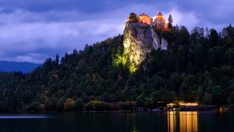 Castle on a cliff overlooking a lake at dusk