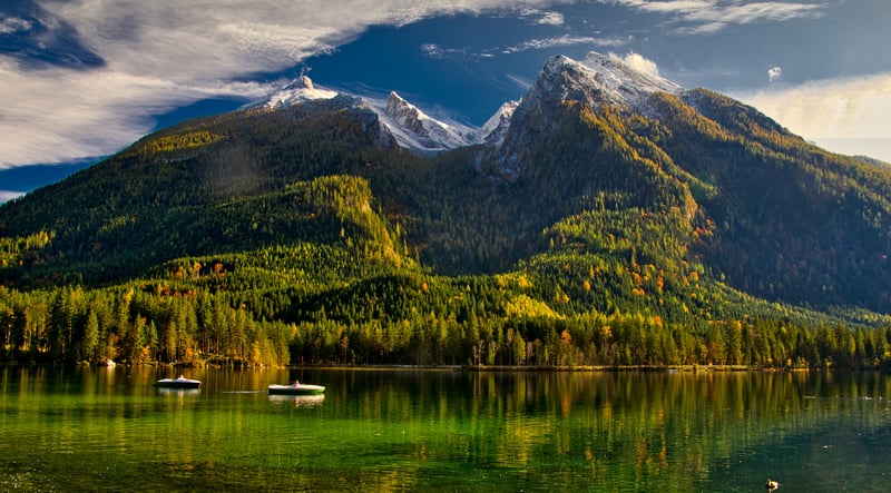 Boats on a lake with mountains and forest