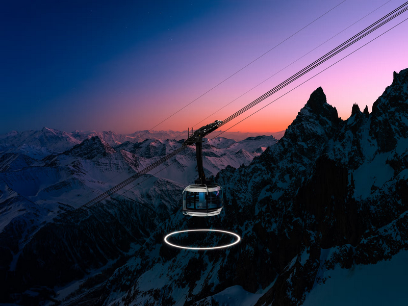 Cable car over snowy mountains at sunrise