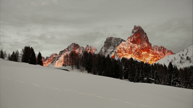 Snowy mountain peaks illuminated by sunset