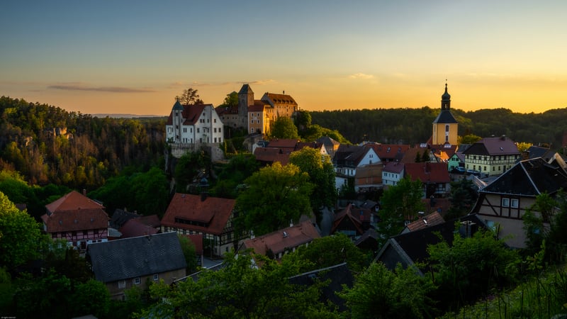 Village and castle at sunset with trees and forest