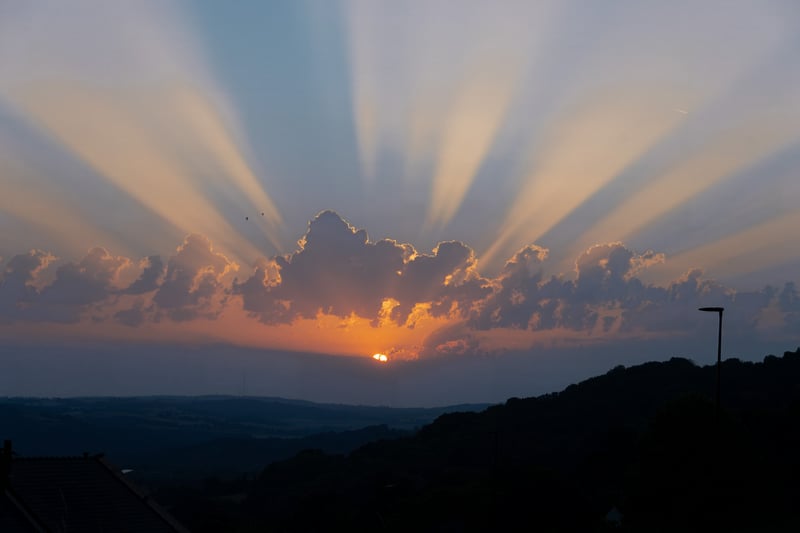 Sunset with crepuscular rays over hills