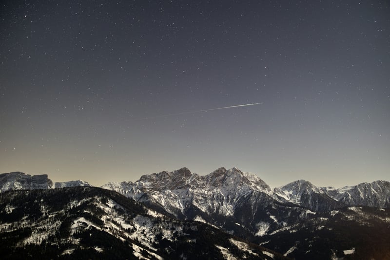 Snow-covered mountains under a starry night sky