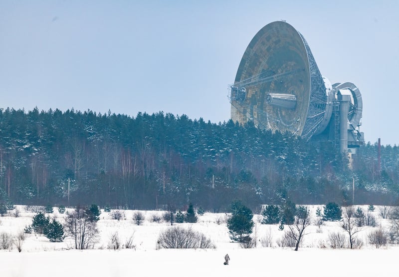 Radio telescope in a snowy landscape with trees