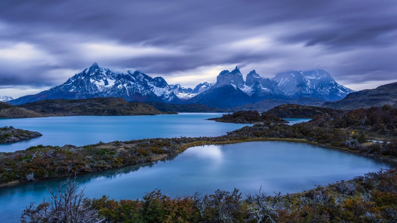 Snow-capped mountains over a blue lake landscape