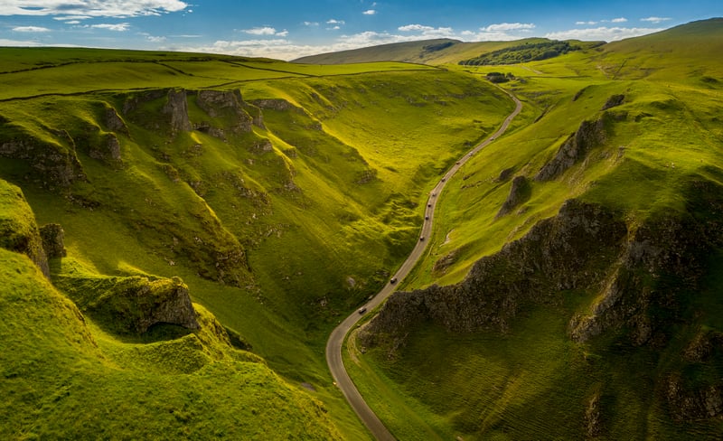 Cars on a road through a green valley