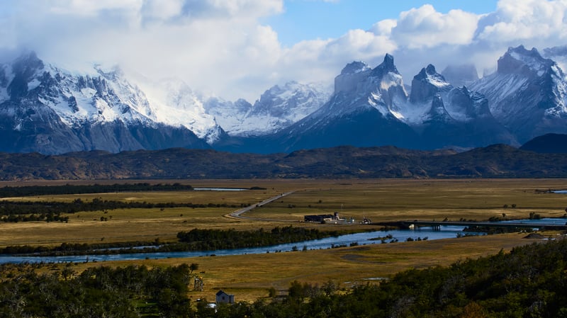 Snow-capped mountains over a wide valley with a river