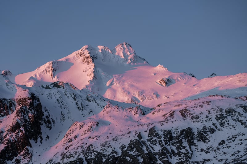 Snow-covered mountains bathed in pink sunset light