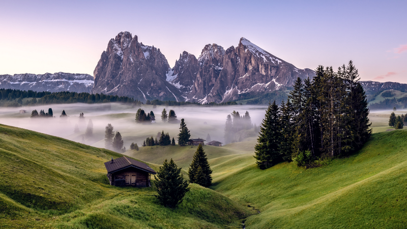 Langkofel mountains with fog and houses in Italy