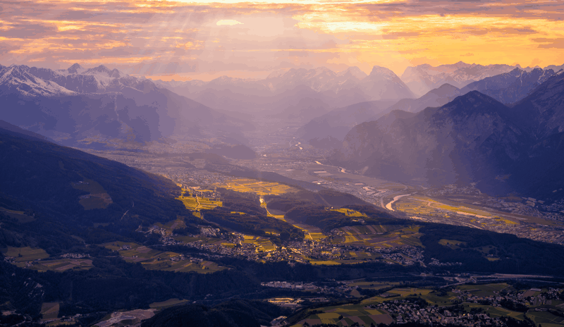 Sun rays over mountains and a valley town